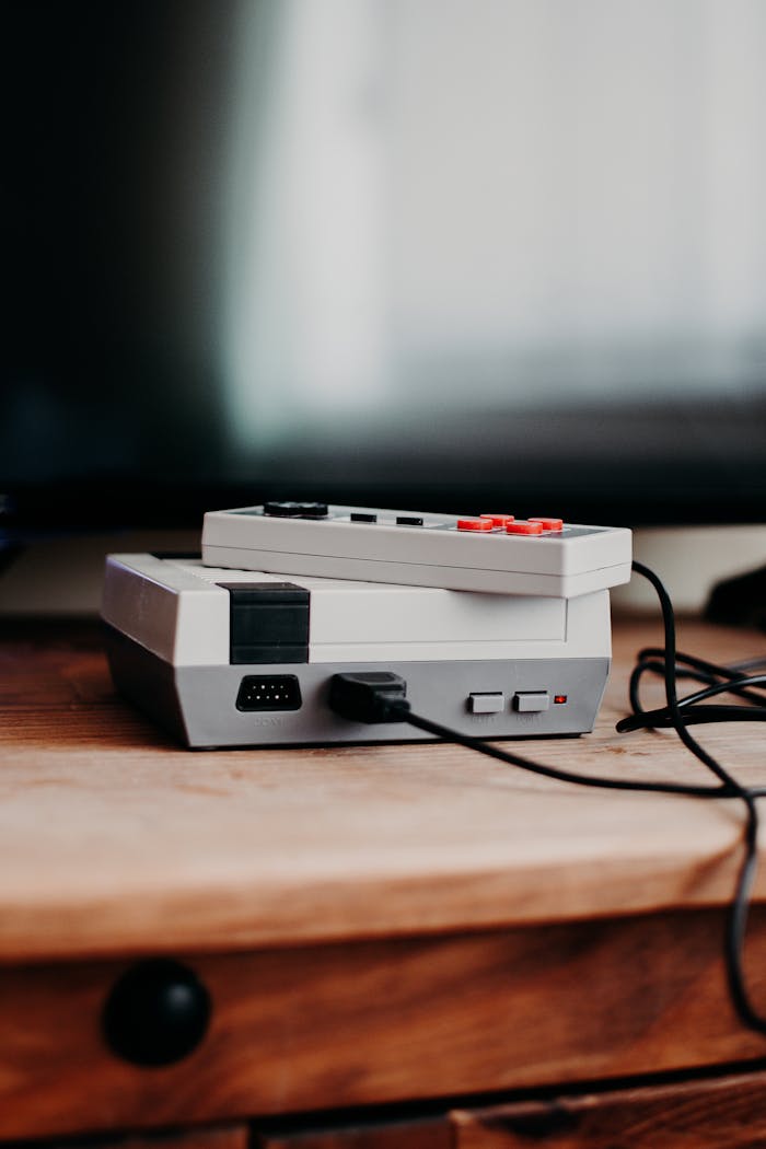 Offerings Vintage gaming console and controller on wooden desk, capturing nostalgic essence.